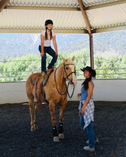 girl standing on horse